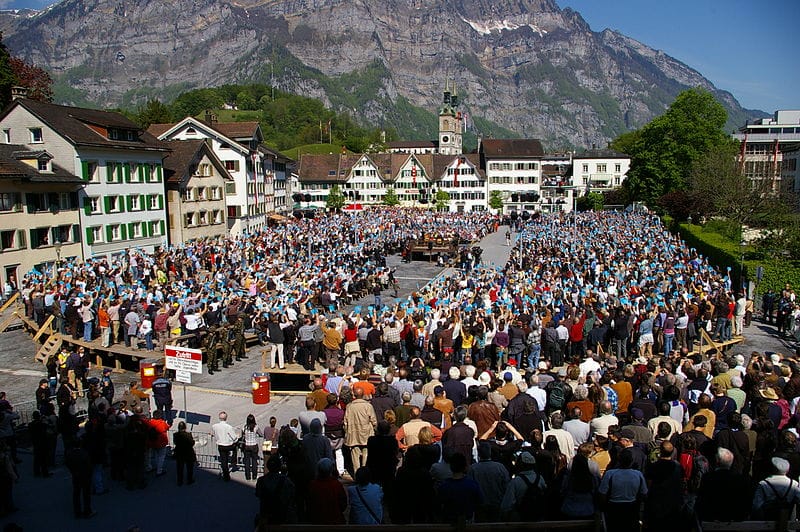 The Landsgemeinde sau "adunarea cantonală" este un sistem de vot public, ne-secret, care funcționează prin regula majorității, constituind una dintre cele mai vechi forme de democrație directă. (Source=http://www.fotocommunity.de/pc/pc/extra/mydiscuss/display/16944106 |Date=3. Mai 2009 |Author=[http://www.icarus-design.ch Marc Schlumpf)
